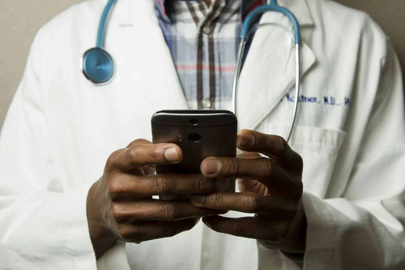 Doctor in a white coat using a smartphone